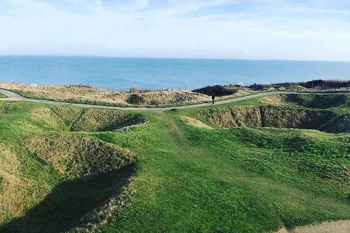 Pointe du Hoc cliffs and bomb craters on a small-group D-Day day trip from Paris to the Normandy landing beaches, France