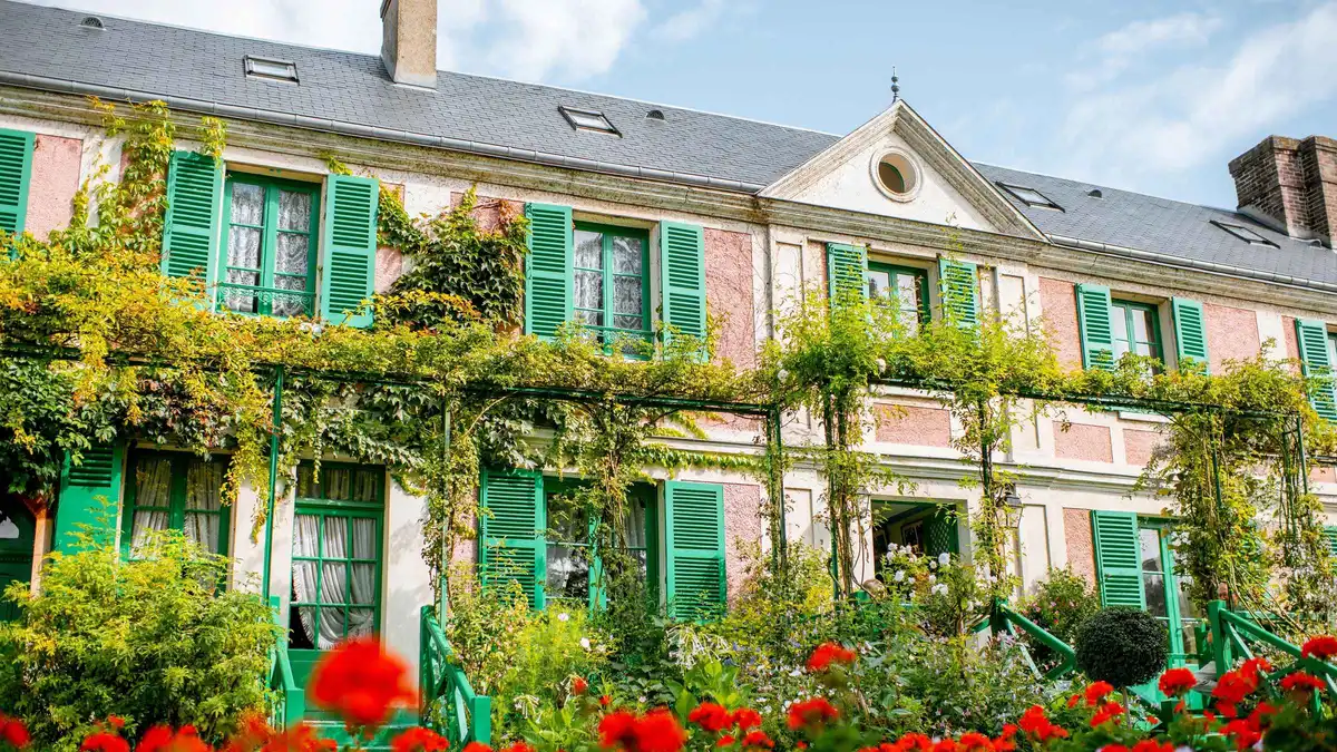 Monet's pink house and flower beds in Giverny on a day tour from Paris to Giverny and Versailles, France