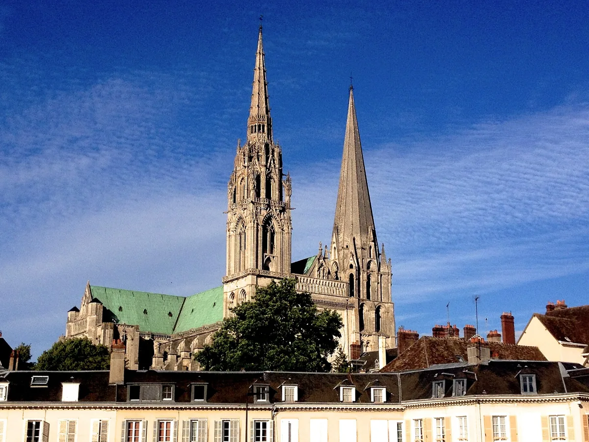 Two spires of Chartres Cathedral against a blue sky on a day trip from Paris