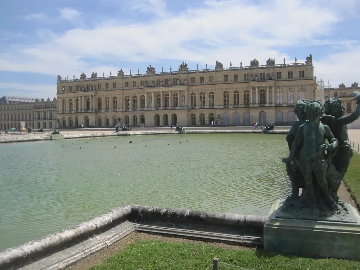 Garden facade of the Palace of Versailles above a fountain basin, seen on a day trip from Paris by train